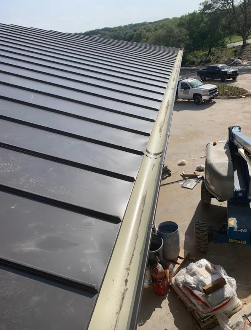 Standing seam panel and gutter detail on a metal roofing jobsite in Gray